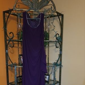 Long and soft gown with studded rhinestone neckline and side ruching.